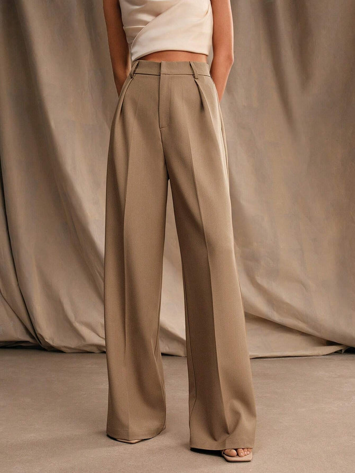 Pantalon femme plissé chic, taille haute et jambes larges, moderne pour un style féminin élégant.