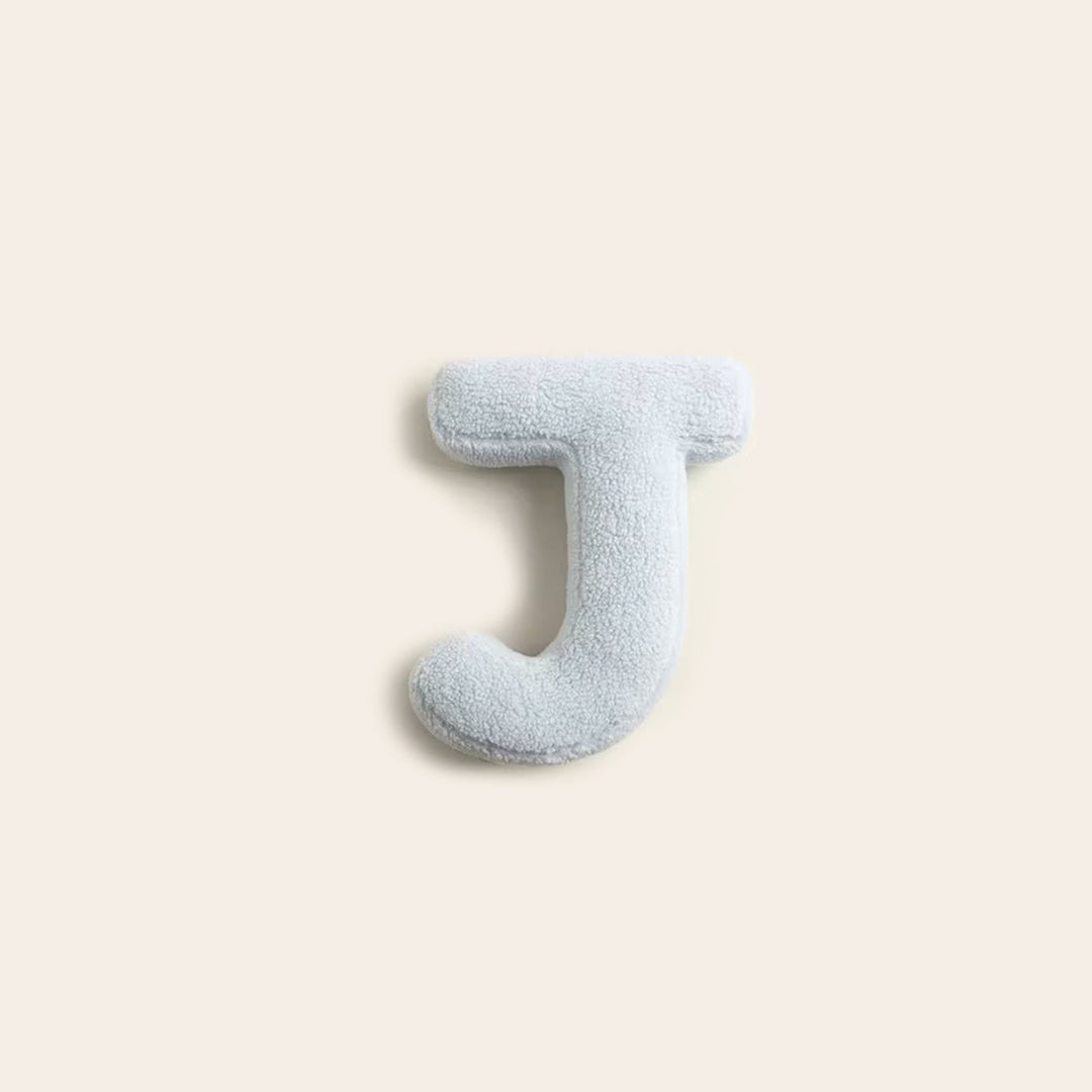 Coussin en coton lettre K, idéal pour une chambre d'enfant cosy.