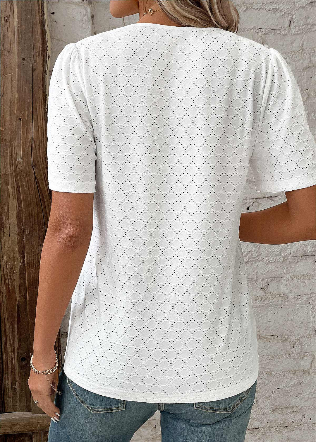 Top femme blanc, manches courtes, boutonnée, broderie raffinée pour un style chic moderne.