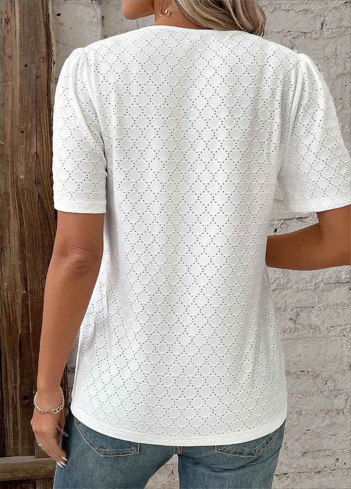 Top femme blanc, manches courtes, boutonnée, broderie raffinée pour un style chic moderne.