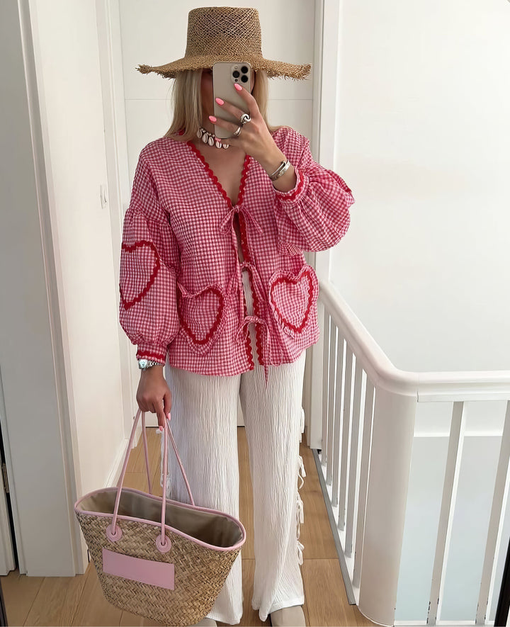 Blouse femme élégante vichy bleue, ouverte avec liens à nouer, manches longues et bord festonné, look chic.