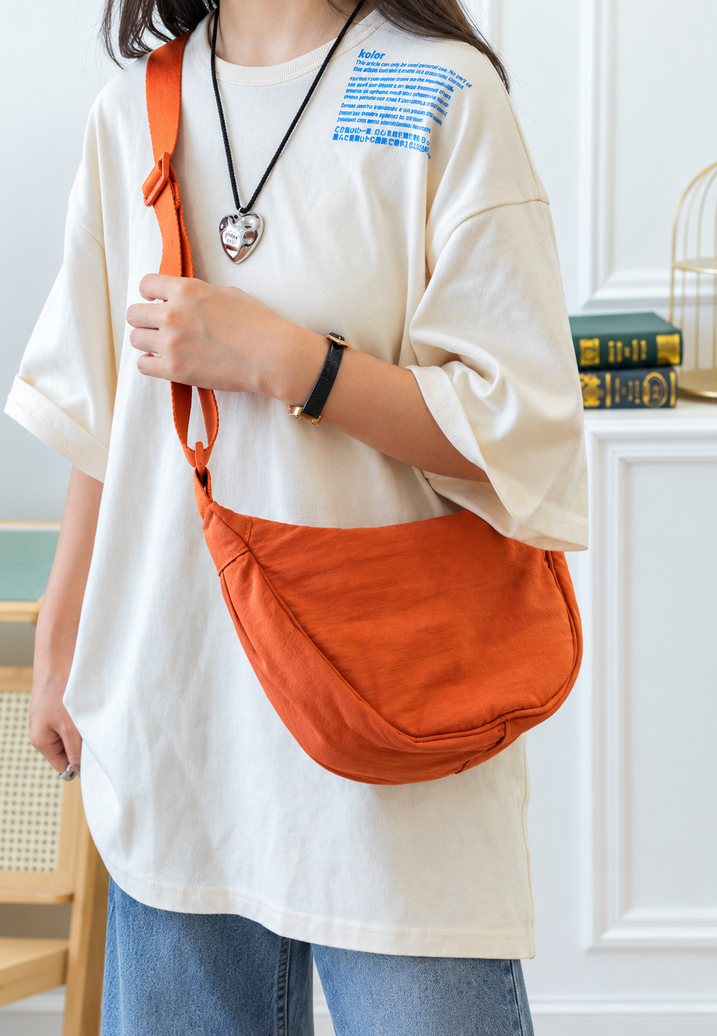 Sac à bandoulière orange femme en nylon, forme demi-lune. Accessoire de mode ajustable et décontracté.