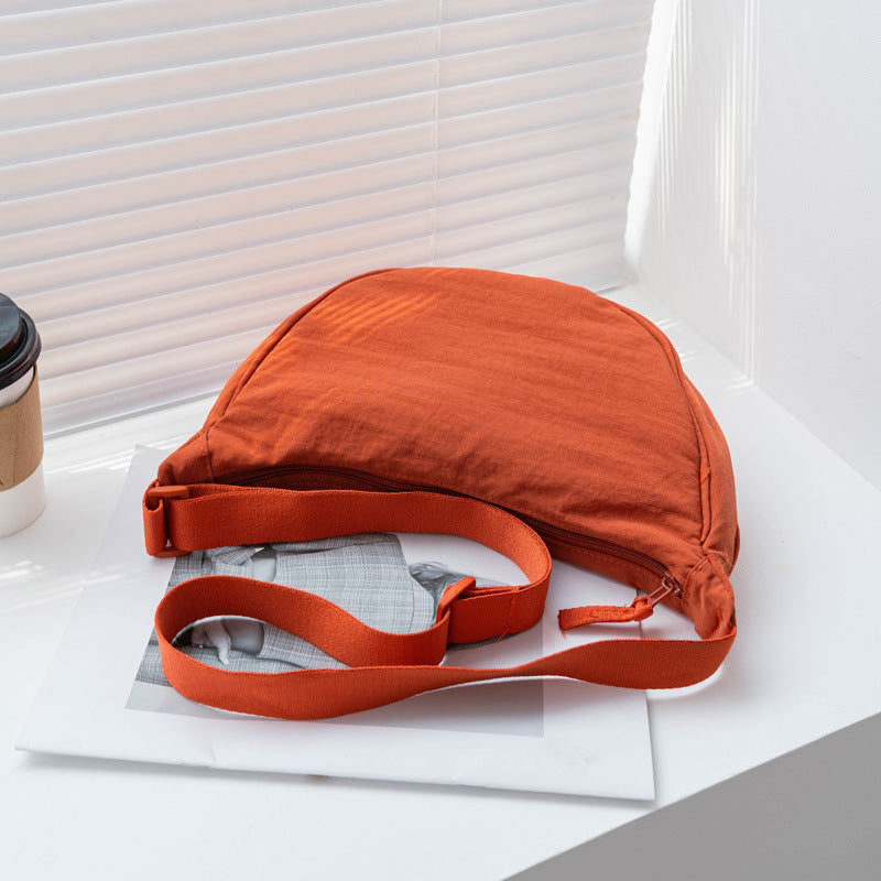 Sac demi-lune ajustable vert militaire en nylon pour femme. Idéal pour un look quotidien.