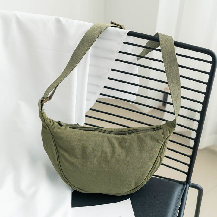 Élégant sac bandoulière beige pour femme, en nylon forme demi-lune. Accessoire mode ajustable.