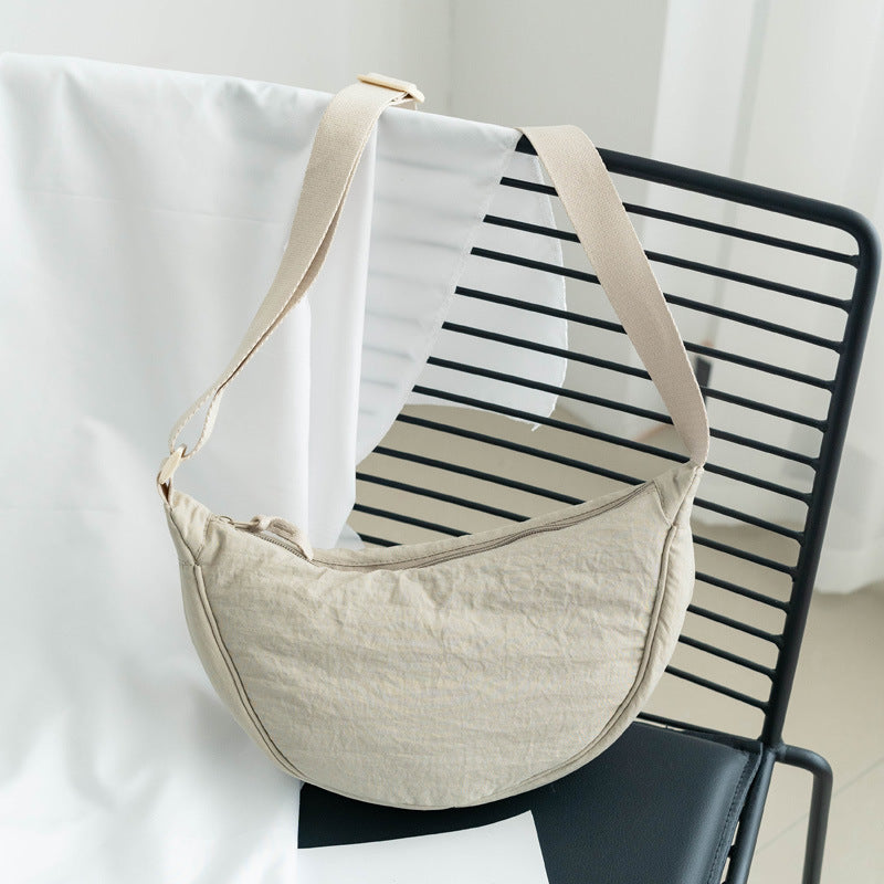 Sac femme bandoulière ajustable en nylon. Design demi-lune décontracté, parfait pour tous les jours.