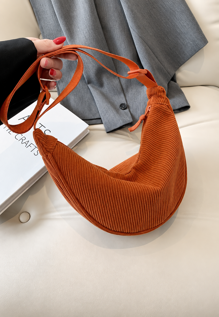 Élégant sac à main femme forme demi-lune, texture raffinée, idéal pour un usage quotidien.