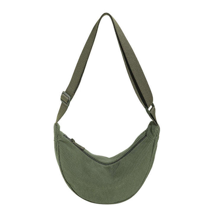 Sac bandoulière demi-lune texturé porté par une femme, incarnant l'élégance moderne et quotidienne.