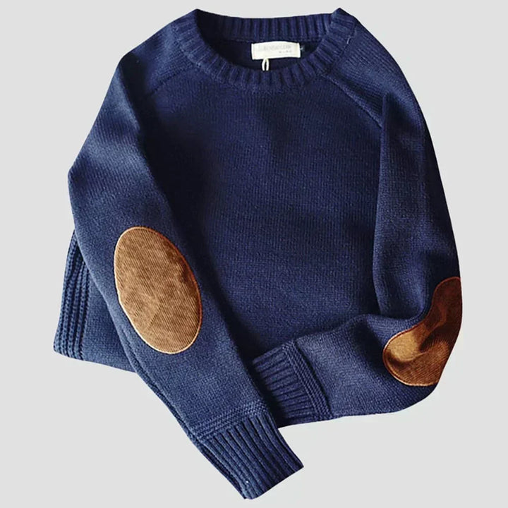 Détail des patches en suédine sur les coudes d'un pull classique homme, ajoutant une touche chic et originale.