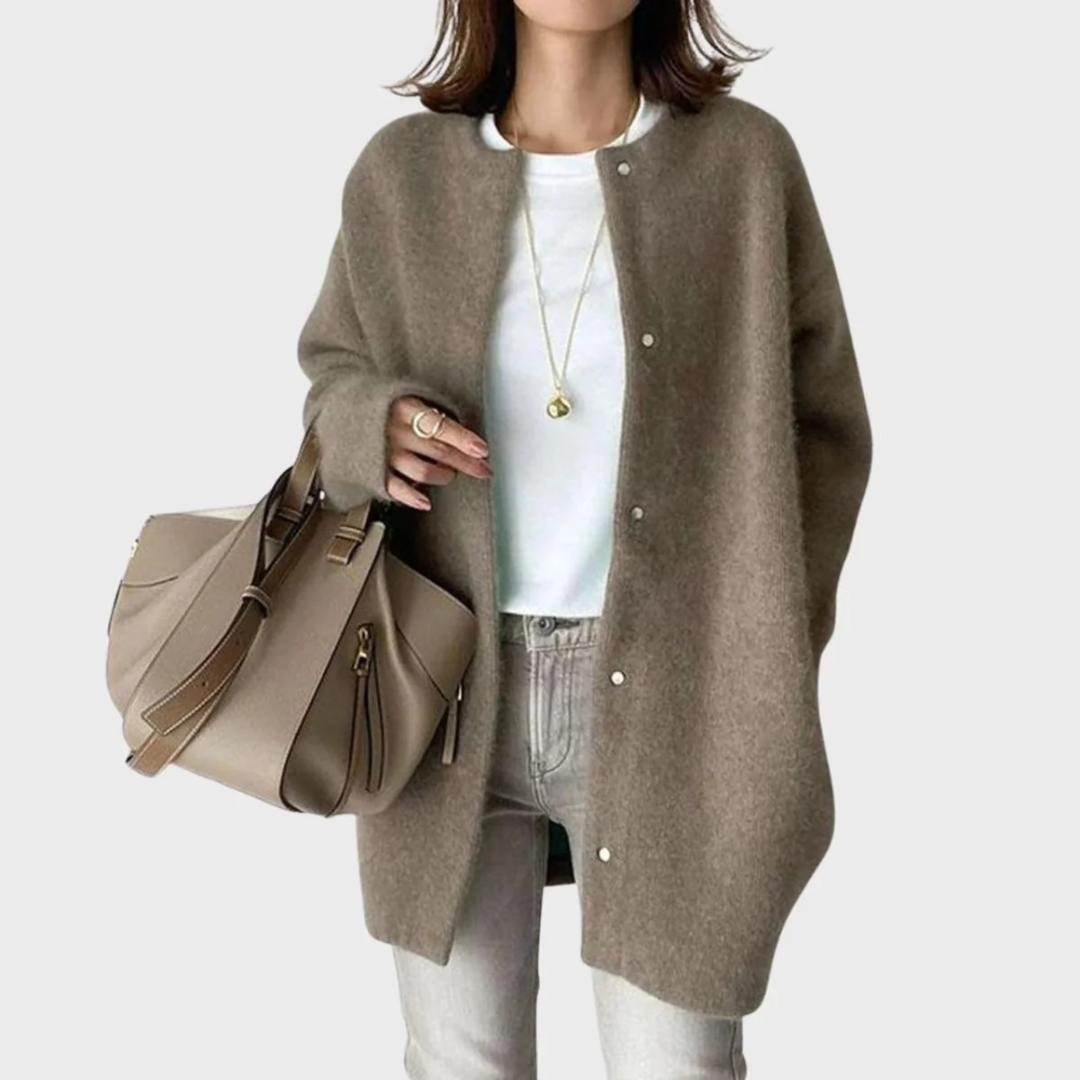 Femme souriante portant un cardigan long oversize camel avec un jean, look décontracté chic et confortable.