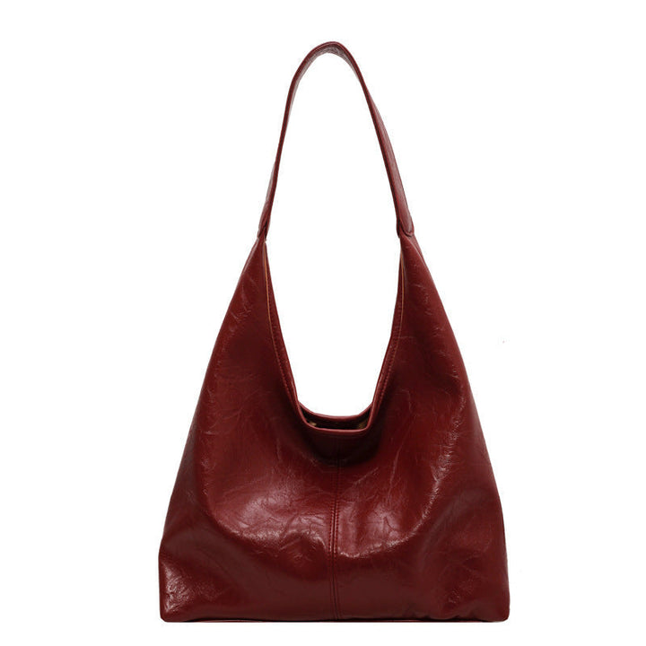 Fermeture dorée sur sac à main bandoulière femme en cuir vegan noir, pochette incluse.