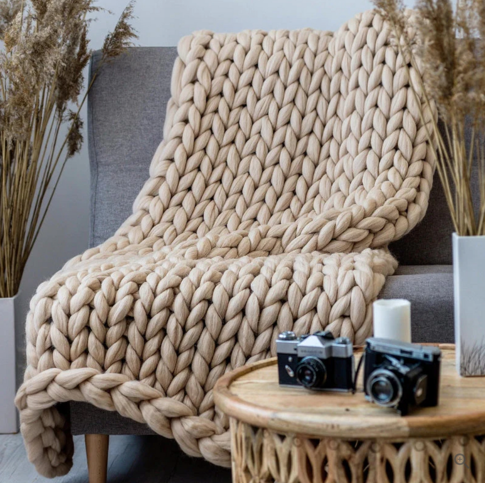 Joli plaid en laine mérinos tricotée, offrant une douceur et une chaleur incomparables pour votre chambre ou canapé.