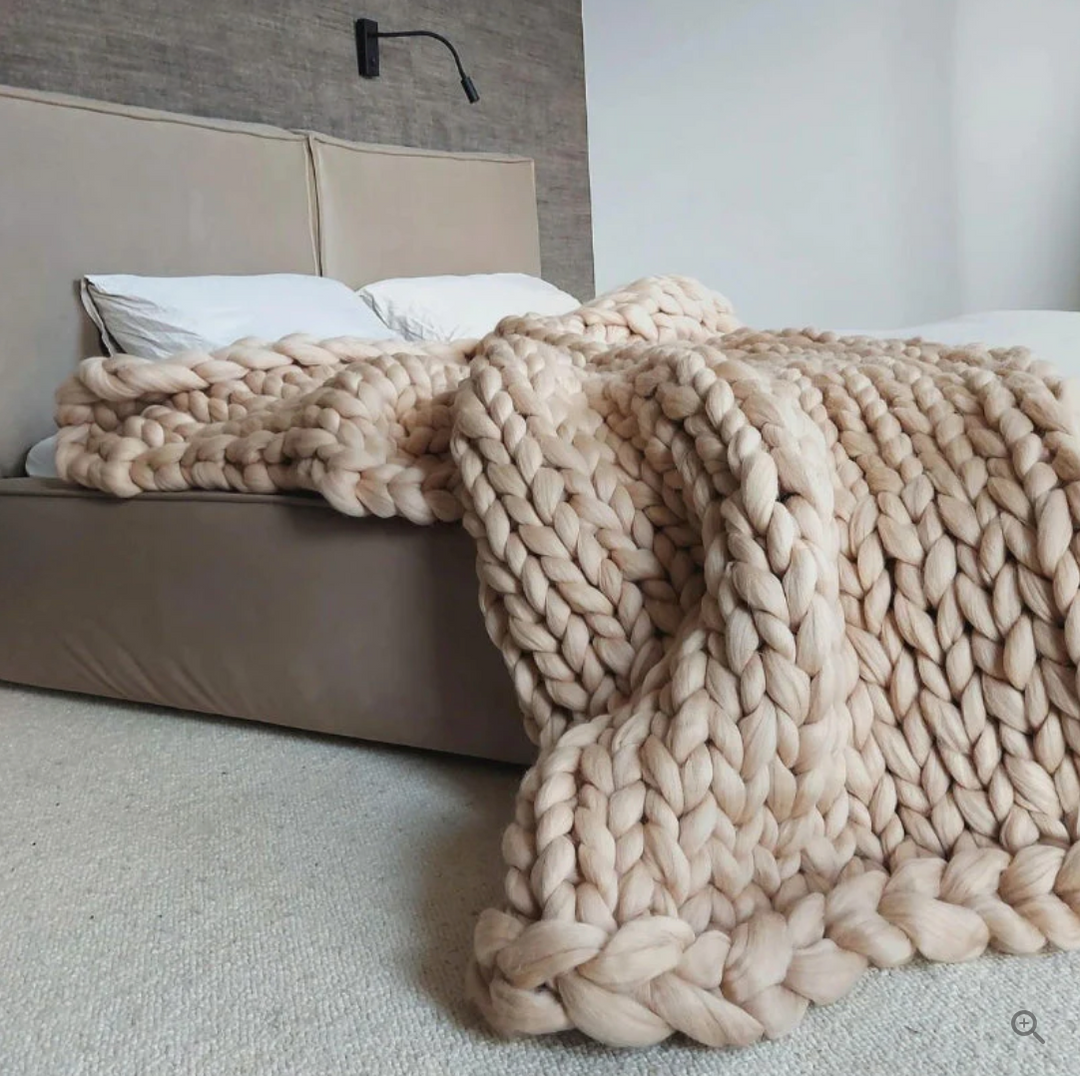 Élégante couverture en laine mérinos tricotée, un jeté doux et chaud, idéal pour le confort cosy du salon.