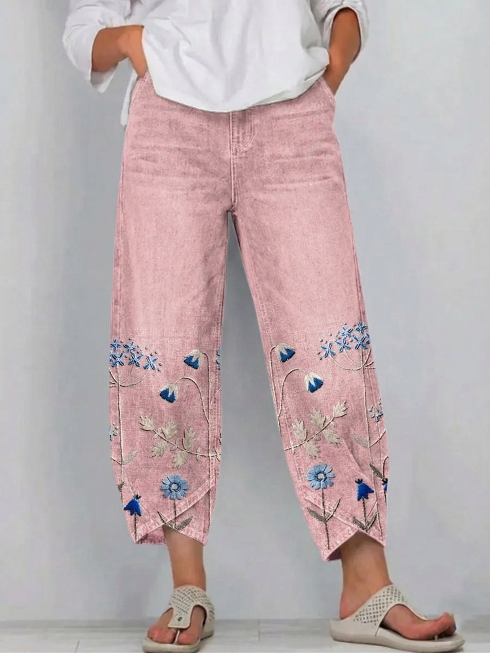 Détail des broderies florales artisanales sur pantalon denim femme coupe droite style bohème chic.