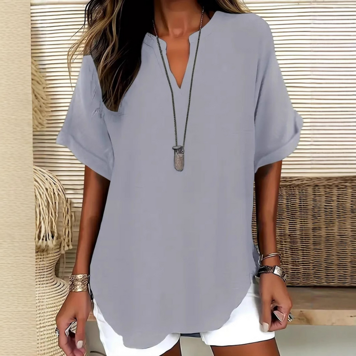 Blouse femme élégante, col V, manches courtes, ourlet arrondi. Offre un look fluide et chic pour toute occasion.