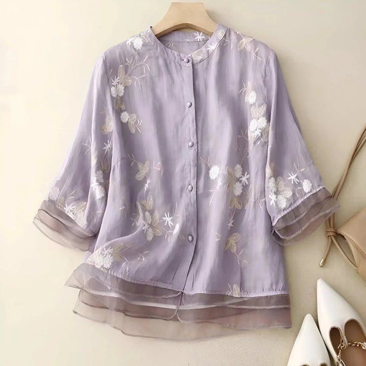 Blouse fluide femme décontractée à broderie florale. Col rond et détails boutons.