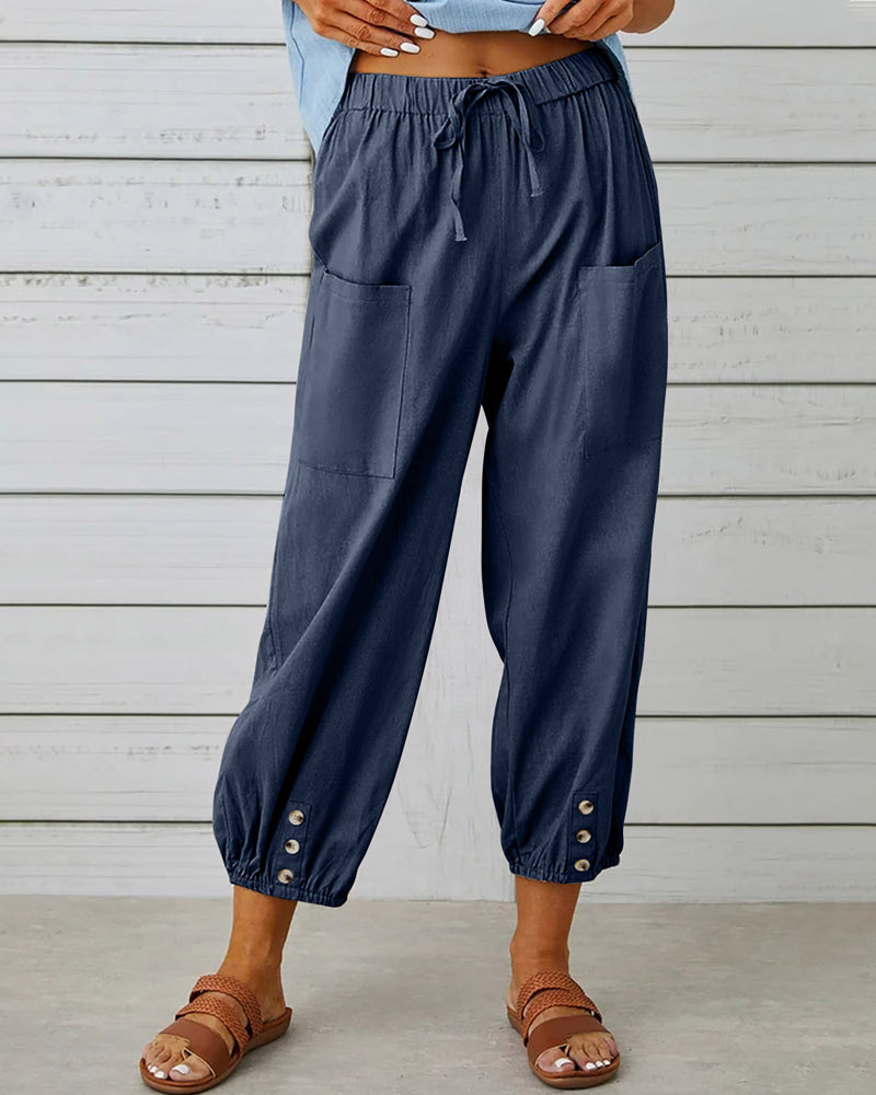 Sarouel ample femme avec ceinture élastique et détails boutons. Idéal pour un look casual mode printemps-été.