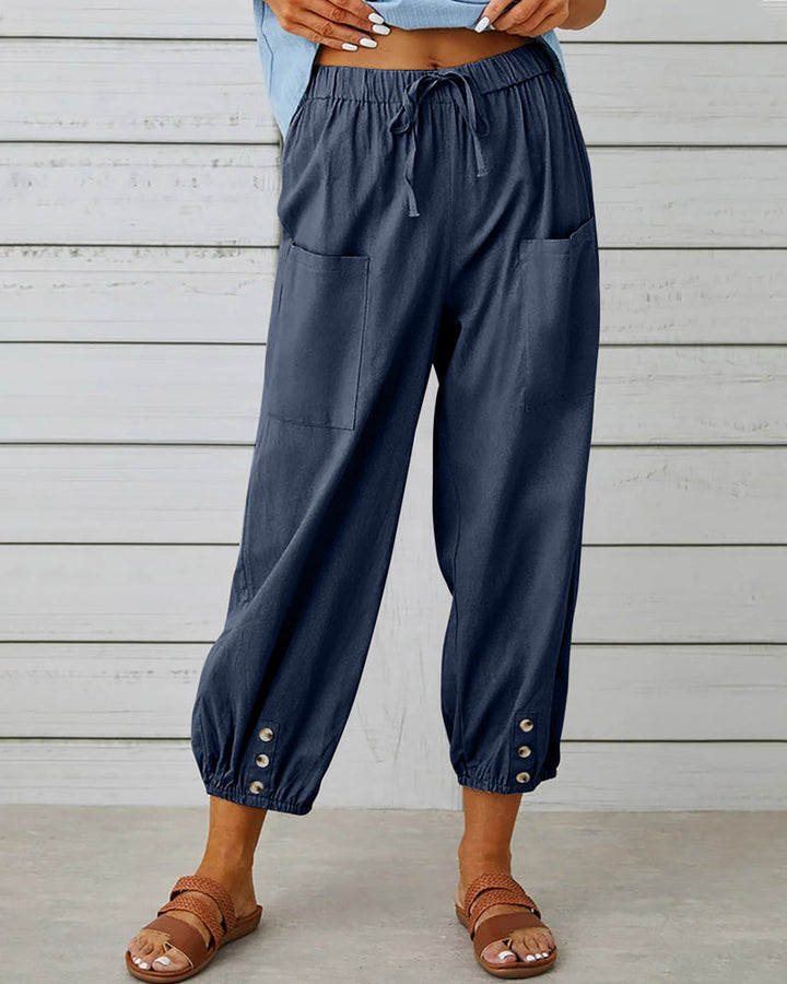 Sarouel ample femme avec ceinture élastique et détails boutons. Idéal pour un look casual mode printemps-été.