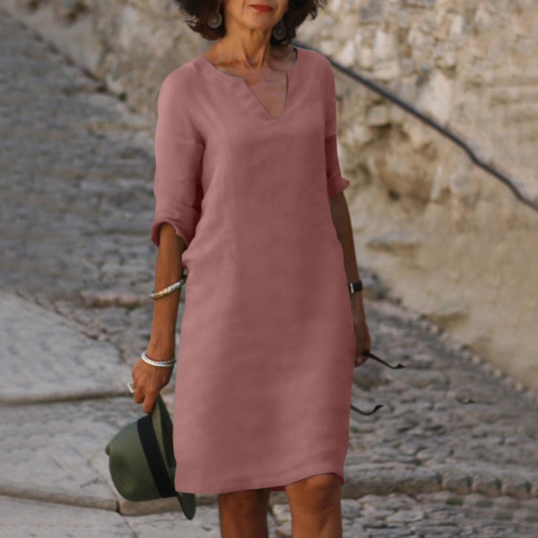 Photographie d'une robe midi ample femme avec col en V et manches trois-quarts. Confort et style.