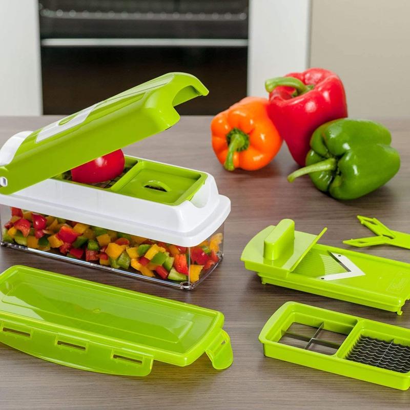 Main coupant des carottes avec le coupe-légumes multifonction, préparation culinaire rapide et sécurisée des légumes.