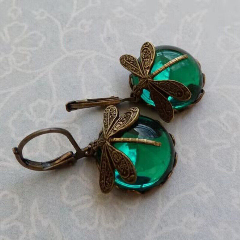 Gros plan sur les boucles d'oreilles libellule pierre de lune, design vintage, cadeau idéal pour femme.