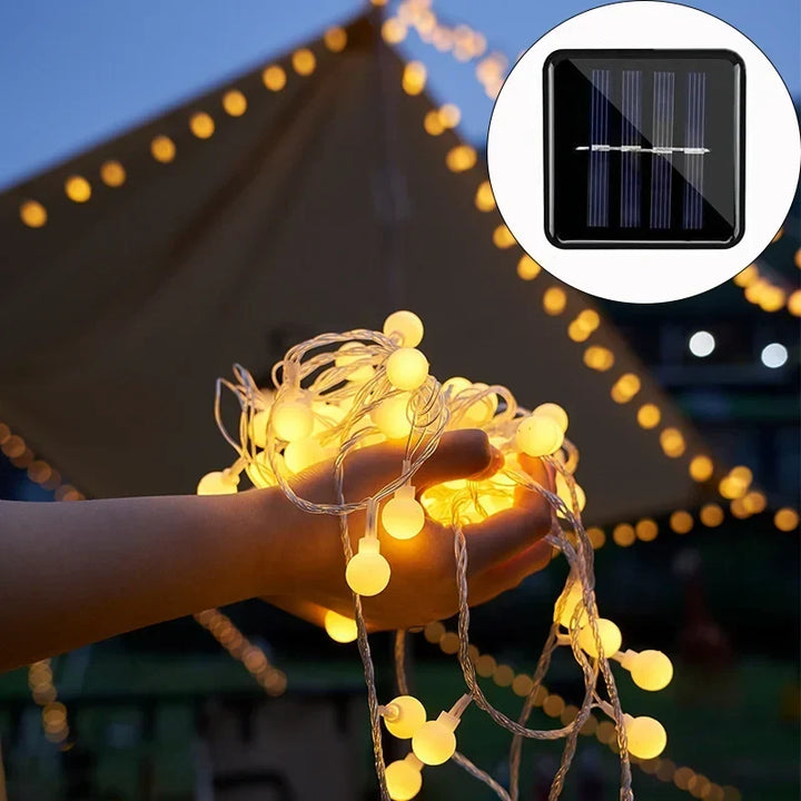 Guirlande LED solaire IP65 illuminant une terrasse, idéale pour les repas et fêtes en extérieur.
