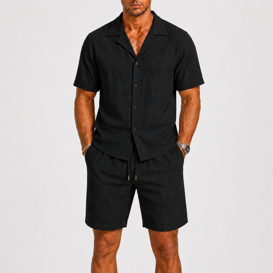 Homme portant un ensemble estival chemise col cubain et short, look décontracté pour les vacances et la plage.
