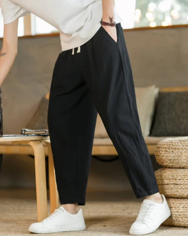 Vue avant du pantalon homme ample à plis. Cordon de serrage visible, taille élastique pour un ajustement parfait.