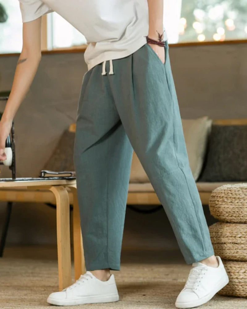 Mode homme: Pantalon ample et moderne à plis. Taille élastique et cordon pour un look décontracté et tendance.