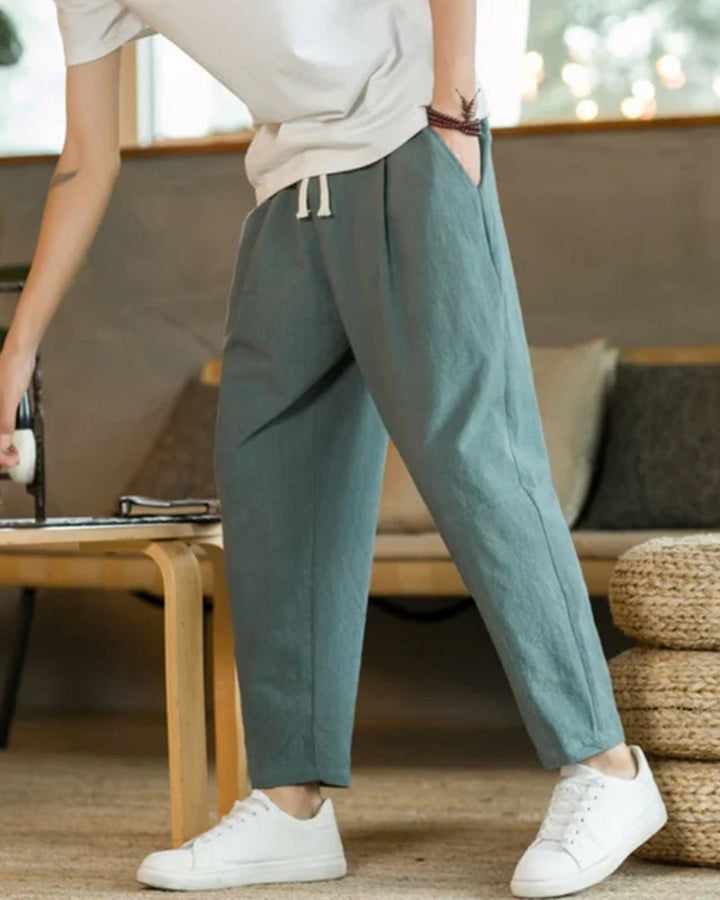 Mode homme: Pantalon ample et moderne à plis. Taille élastique et cordon pour un look décontracté et tendance.
