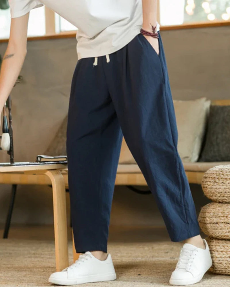 Détail du pantalon homme ample à plis avec taille élastique et cordon. Confort et style décontracté garantis.