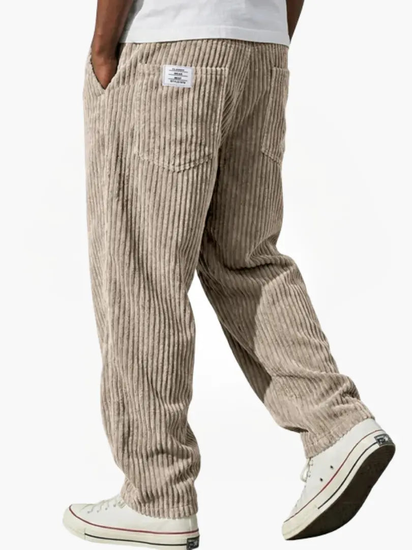 Pantalon large côtelé pour homme, taille élastique et poches. Confort décontracté ultime, mode masculine.