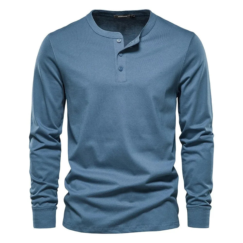 Modèle homme portant un t-shirt Henley gris, manches longues, coupe droite. Idéal pour un look quotidien chic.