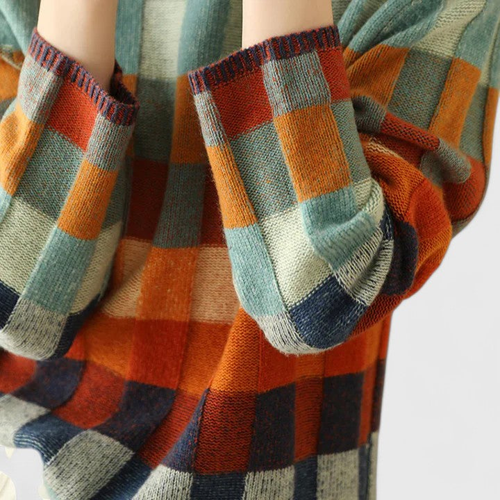 Détail du pull femme à carreaux multicolores, montrant le tissu doux et la coupe confortable du tricot.