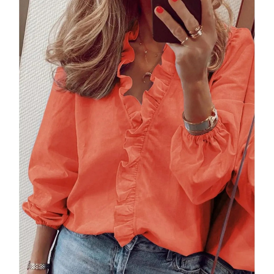 Haut femme élégant avec un imprimé vibrant et un col V volanté. Cette blouse offre style et confort extensible.