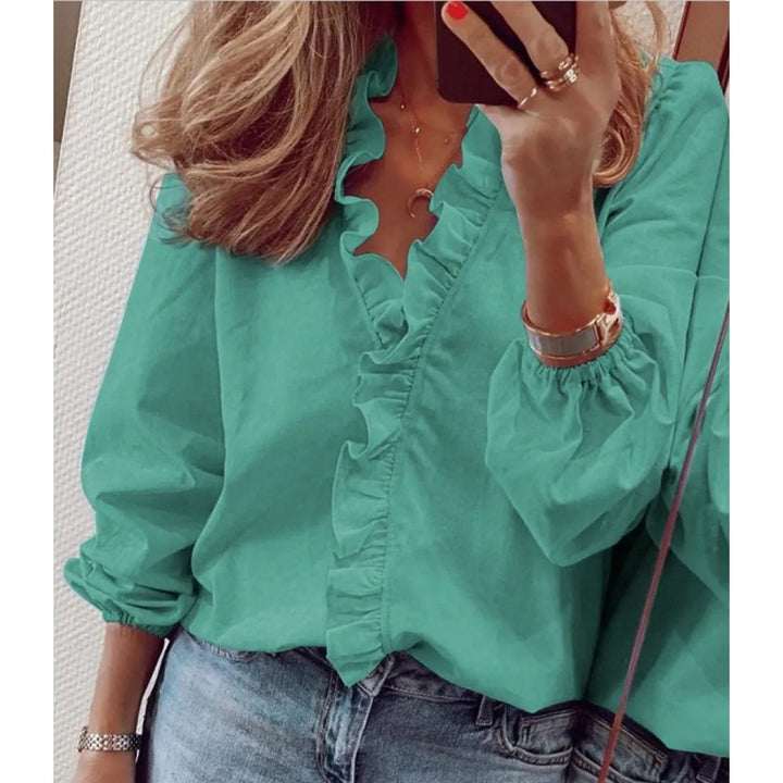 Haut femme mode à motif imprimé, col V orné de volants. Parfait pour un look décontracté-chic au printemps.