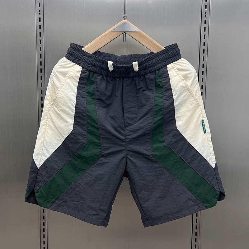 Short de sport homme contrasté design géométrique. Idéal pour l'athlétisme et le confort estival.