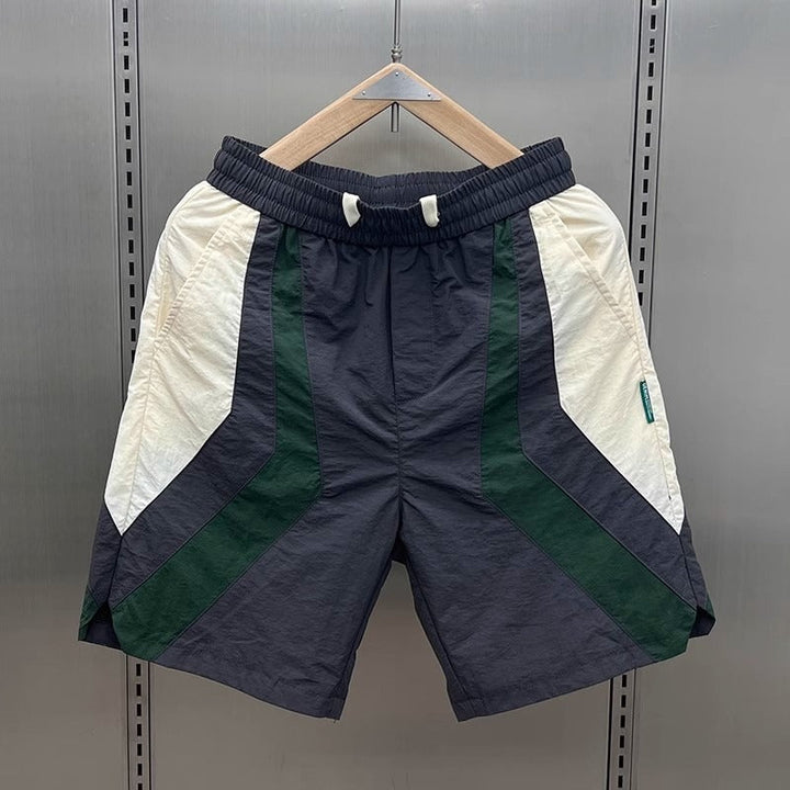 Short de sport homme contrasté design géométrique. Idéal pour l'athlétisme et le confort estival.