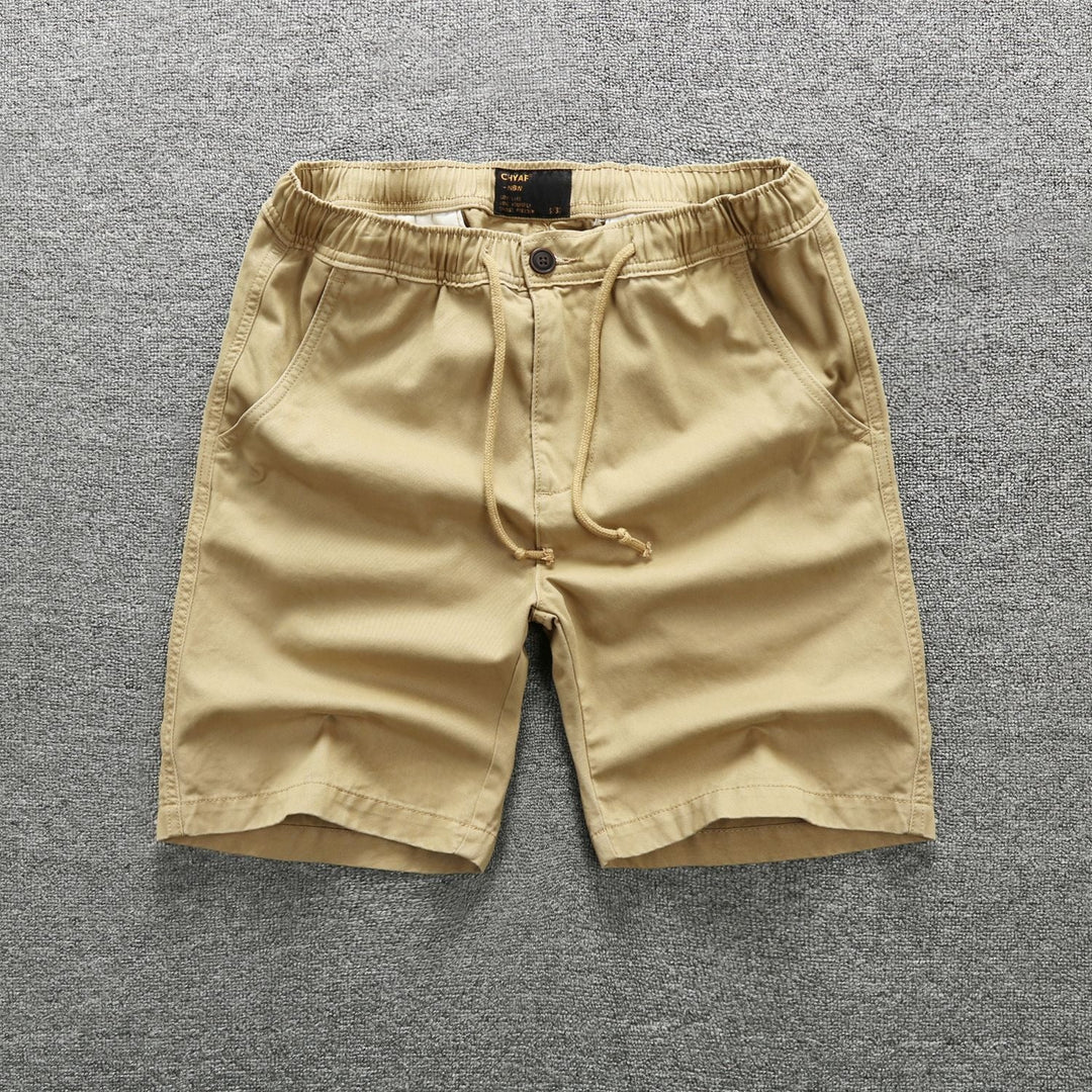 Homme portant un short cargo camouflage militaire, style décontracté et moderne. Parfait pour l'été et plein air.