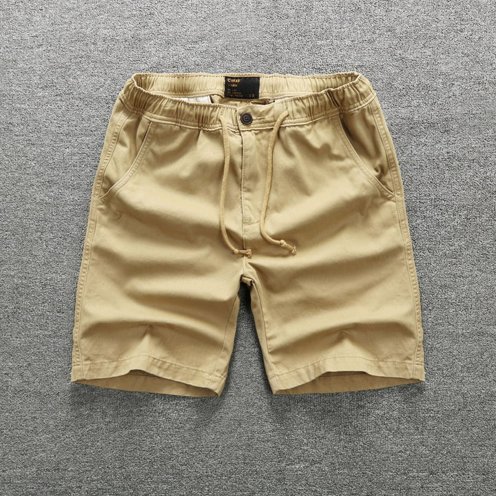 Homme portant un short cargo camouflage militaire, style décontracté et moderne. Parfait pour l'été et plein air.