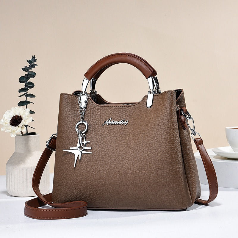 Sac à main femme élégant en simili-cuir avec détail pendentif, accessoire chic et polyvalent.