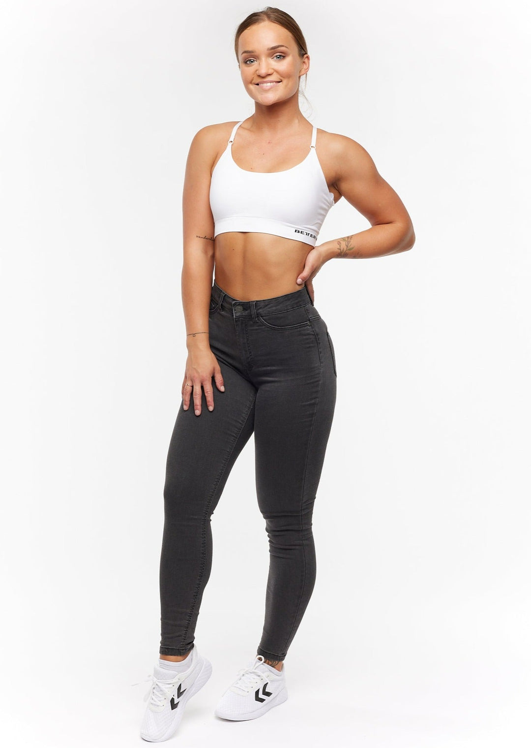 Femme élégante portant un jean skinny taille haute bleu, look tendance et polyvalent.