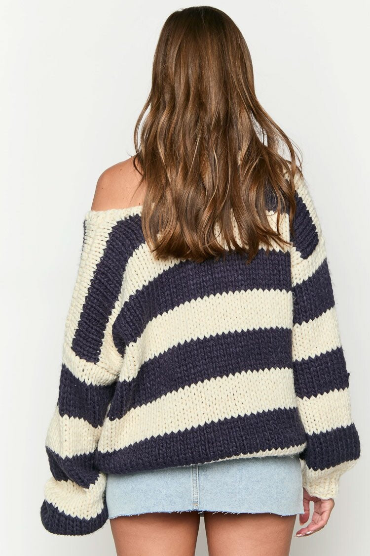 Pull confortable femme à rayures, oversize et épaules dénudées, pour un style chic et moderne.