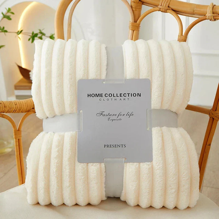 Grande couverture polaire rayée, parfaite pour se blottir et apporter de la chaleur au salon.