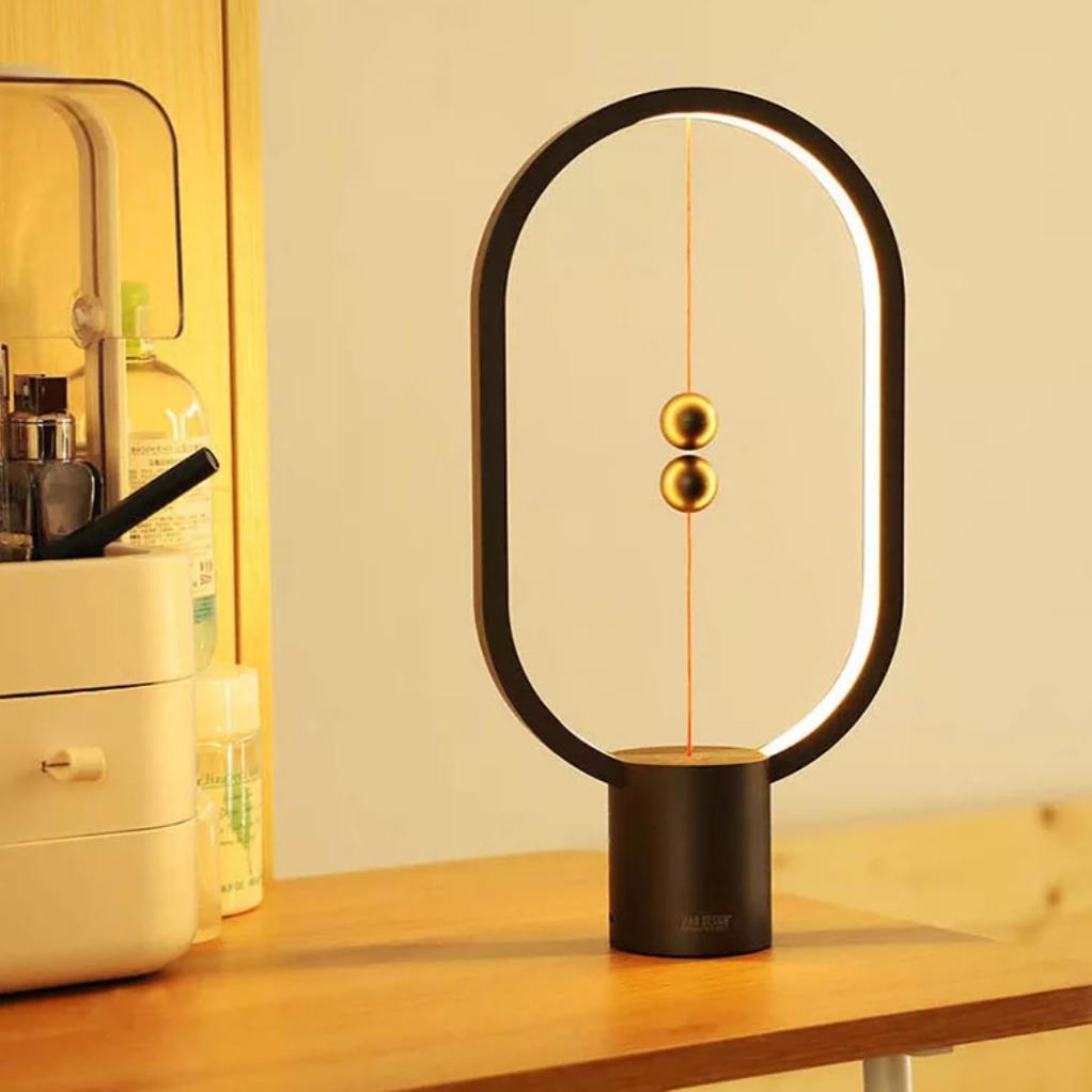 Lampe de table LED design équilibrée avec interrupteur flottant, idéale pour éclairage de bureau et déco moderne.