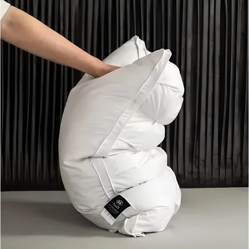 Coussin en duvet d'oie moelleux sur un lit, améliorant le confort de la literie pour un sommeil profond et reposant.