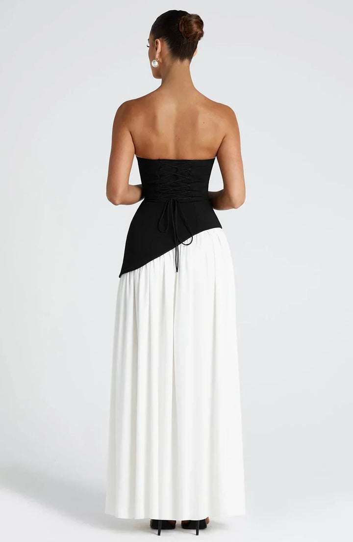 Tenue de soirée femme: robe longue bicolore raffinée, fente audacieuse, foulard chic.