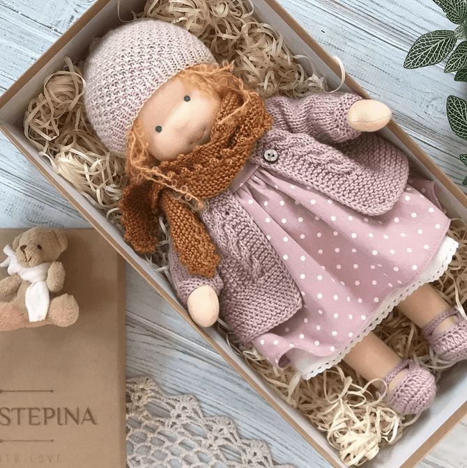Enfant jouant avec sa poupée Waldorf artisanale, un jouet en textile doux et naturel, parfait pour câliner.