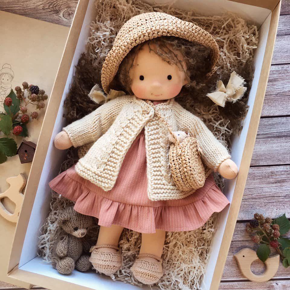 Poupée Waldorf artisanale habillée de vêtements simples, posée, mettant en valeur son design naturel et doux.