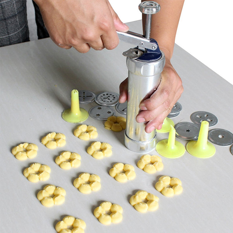 Appareil manuel à biscuits en acier inoxydable, parfait pour la pâtisserie et la création de desserts variés.