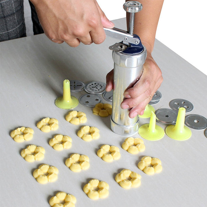 Appareil manuel à biscuits en acier inoxydable, parfait pour la pâtisserie et la création de desserts variés.